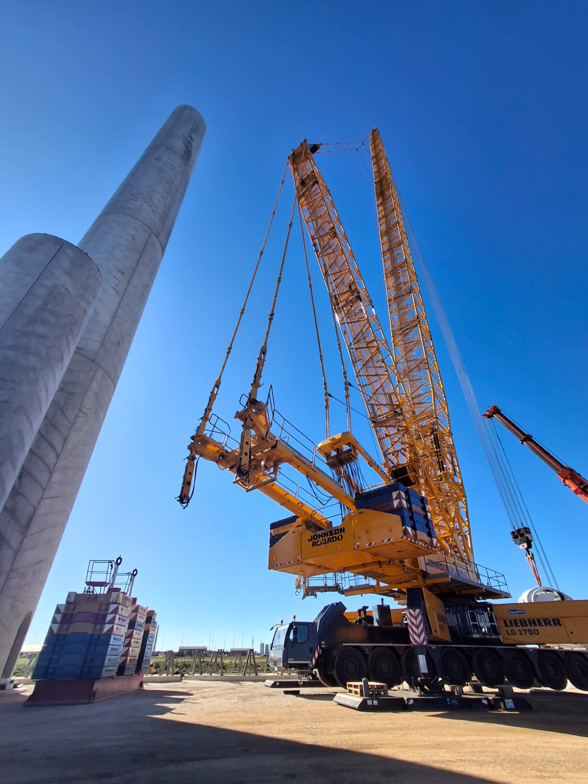 Crawler crane erecting a concrete wind turbine tower section